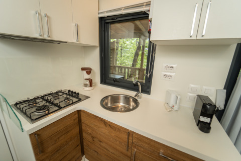 Moderne kitchenette bij Chianti Glamping Resort met gaskookplaat, wasbak en uitzicht op de natuur.
