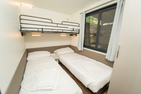 Moderne glampingaccommodatie bij Chianti Glamping Resort met twee eenpersoonsbedden en een hoogslaper.