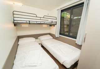 Moderne glampingaccommodatie bij Chianti Glamping Resort met twee eenpersoonsbedden en een hoogslaper.