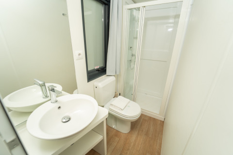 Moderne badkamer in Chianti Glamping Resort - Cottages Toscane met douche, toilet en wastafel.