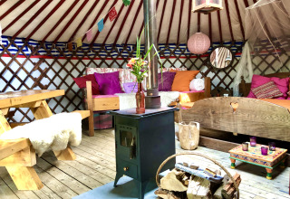 Gezellig interieur van een glamping-yurt bij 'Glamping 't Buitenland - Yurts Brabant' met kleurrijke inrichting.