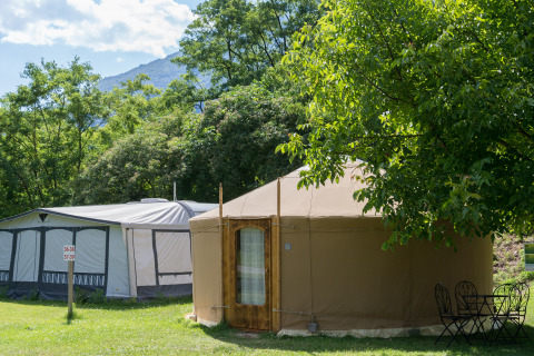 Glamping-accommodatie met Mongoolse yurt en tent omringd door bomen op Camping Bellinzona in Zwitserland.