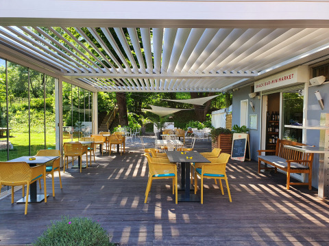 Espace repas extérieur au Camping Bellinzona - Mongoolse Yurt Zwitserland avec chaises jaunes, vue verdoyante.