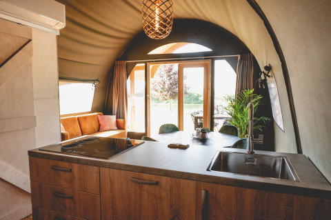 Modern glamping accommodation at Camping De Bovenberg – Lodgetenten Twente with kitchen and lounge area.