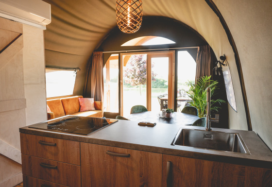 Sistemazione glamping moderna al Camping De Bovenberg – Lodgetenten Twente con cucina e area lounge.