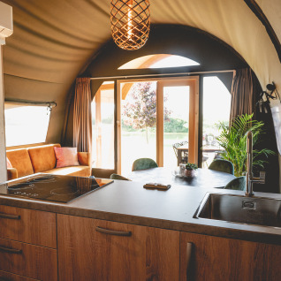 Alojamiento glamping moderno en Camping De Bovenberg – Lodgetenten Twente con cocina y zona de estar.