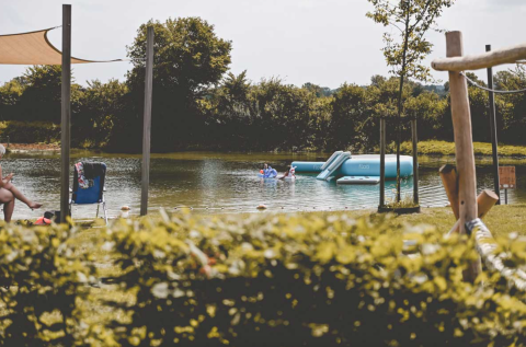 Camping De Bovenberg – Lodgetenten Twente mit See, Wasseraktivitäten, Rasenfläche und schattigen Sitzplätzen.