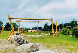 Aire de jeux en bois avec corde et filet d’escalade au Camping De Bovenberg – Lodgetenten Twente, ambiance nature.