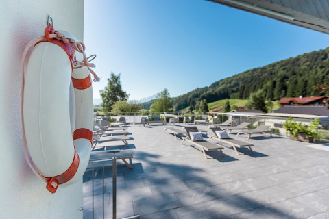 Sonnige Terrasse mit Liegestühlen und Blick auf die Berge bei Camp MondSeeLand - Kampeerhutten Oostenrijk.