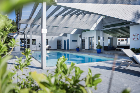 Moderne Glamping-Unterkunft bei Camp MondSeeLand in Österreich mit überdachtem Pool und Lounge.