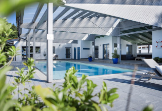 Alojamiento de glamping en Camp MondSeeLand, Austria, con piscina cubierta y zona de descanso moderna.