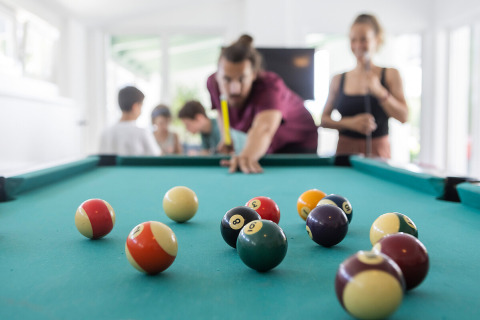 Menschen spielen Billard in entspannter Umgebung bei Camp MondSeeLand - Kampeerhütten Oostenrijk beim Glamping.