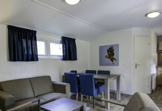 Modern glamping accommodation interior with living, dining, and kitchen at Vakantiepark Havelberge, Netherlands.