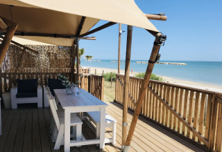 Alloggio glamping con mobili bianchi e vista mare al Villa Alwin Beach Resort sulla spiaggia di Le Marche.