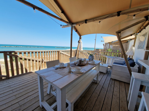 Glamping lodgetent met eethoek en zeezicht aan het strand, Villa Alwin Beach Resort in Le Marche.