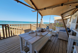 Comedor exterior en tienda glamping frente al mar en Villa Alwin Beach Resort, Le Marche, Italia.