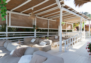 Entspannungsbereich mit Sofas im Villa Alwin Beach Resort, überdacht und umgeben von Natur in Le Marche.