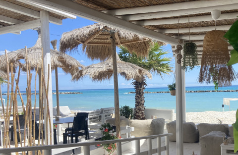 Sala al aire libre con sombrillas y vista al mar en Villa Alwin Beach Resort glamping en Le Marche, Italia.