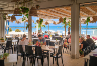 Outdoor dining area at Villa Alwin Beach Resort, guests enjoying meals with beach and sea view in Le Marche.
