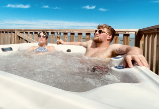 Paar entspannt im Whirlpool auf der Terrasse von Villa Alwin Beach Resort, Glamping am Strand in Le Marche.