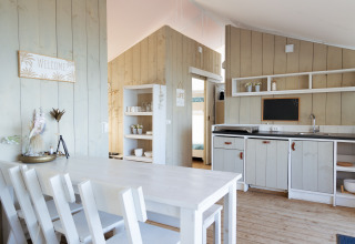 Luxe glamping keuken en eetruimte bij Villa Alwin Beach Resort, met houten wanden en wit meubilair.
