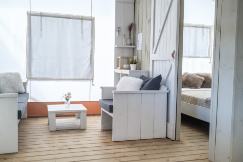 Vista interior de una tienda glamping de lujo en Villa Alwin Beach Resort con muebles blancos modernos.