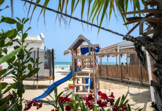 Parco giochi in spiaggia con scivolo e altalene tra lodge di lusso a Villa Alwin Beach Resort, Le Marche.
