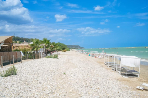 Villa Alwin Beach Resort - Luxe lodgetenten aan het strand in Le Marche met zeezicht en loungestoelen.