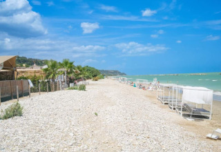 Villa Alwin Beach Resort - Luxe lodgetelte ved stranden i Le Marche med udsigt over havet og liggestole.