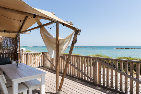 Udendørs terrasse med havudsigt ved Villa Alwin Beach Resort glamping i Le Marche, Italien.