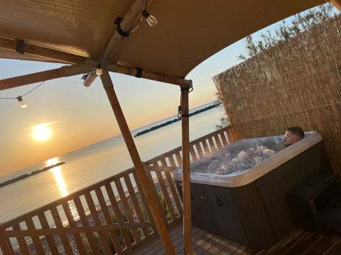 Villa Alwin Beach Resort glamping, hot tub on the deck overlooking the sunset and sea in Le Marche, Italy.