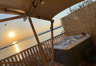 Glampingverblijf Villa Alwin Beach Resort, bubbelbad op terras met zeezicht en zonsondergang in Le Marche.