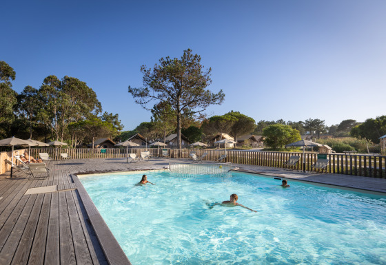Piscina al aire libre con huéspedes en Huttopia Lagoa de Óbidos Glamping Portugal rodeada de naturaleza.