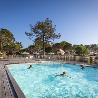 Piscina all'aperto con ospiti presso Huttopia Lagoa de Óbidos Glamping in Portogallo, immersa nella natura.