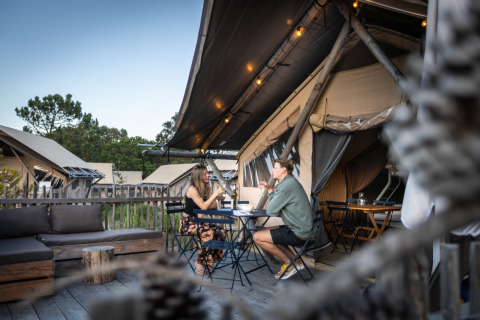 Zwei Personen essen draußen vor Glamping-Zelten im Huttopia Lagoa de Óbidos, Glamping Portugal.