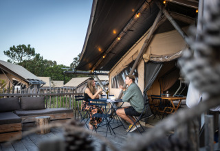 Zwei Personen essen draußen vor Glamping-Zelten im Huttopia Lagoa de Óbidos, Glamping Portugal.
