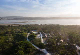 Huttopia Lagoa de Óbidos, site de glamping au Portugal avec cabanes entourées de verdure près du lagon.