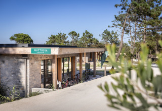 Empfangsbereich von Huttopia Lagoa de Óbidos Glamping in Portugal, umgeben von Bäumen und Natur.