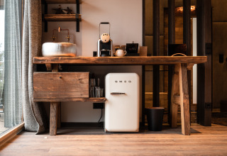 Pequeña cocina rústica con mini nevera SMEG y cafetera en la cabaña glamping de Gassner Boomhut Austria.