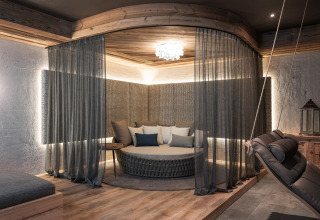Stylish and modern glamping suite at Wander- & Wellnesshotel Gassner Boomhut Austria with circular bed and drapes.