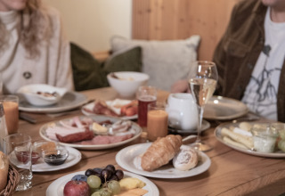 Couple prenant un petit déjeuner chaleureux avec croissant, fruits et boissons à Wander- & Wellnesshotel Gassner en Autriche.