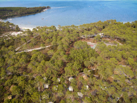 Vue aérienne de Huttopia Lac de Carcans Glamping Aquitaine, tentes glamping dispersées dans la pinède au bord du lac.