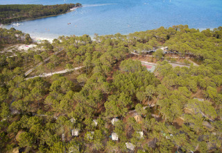 Luchtfoto van Huttopia Lac de Carcans Glamping Aquitaine, met tenten tussen dennen aan het meer.