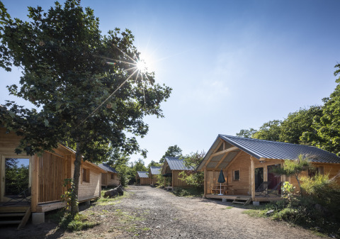 Hébergements glamping en chalets boisés et ensoleillés à Huttopia Royat - Glamping Auvergne, au cœur de la nature.