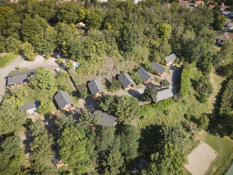Luftaufnahme von Huttopia Royat - Glamping Auvergne mit kleinen Hütten im grünen Wald gelegen.