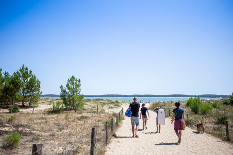Family walking toward the beach at Huttopia Oléron les Chênes Verts - Glamping Nouvelle Aquitaine on a sunny day.