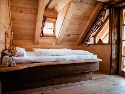 Cozy wooden cabin with sloped ceiling, double bed and rustic decor at s'Baumhaus Dörfle - Boomhutten Zwarte Woud.
