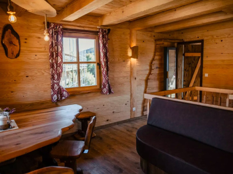 Innenaufnahme von s'Baumhaus Dörfle - Boomhutten Zwarte Woud mit Holzmöbeln und rustikaler Atmosphäre.