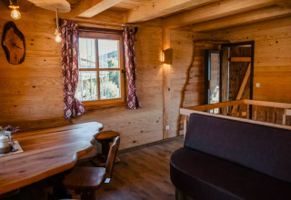 Interno di s'Baumhaus Dörfle - Boomhutten Zwarte Woud con arredi in legno e finestra panoramica.