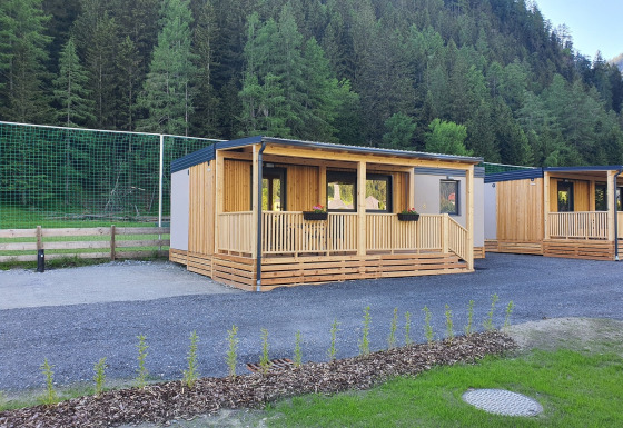 Moderne glampinghuisjes met houten terras bij HochOBEN - Stacaravans Oostenrijk, midden in de natuur.